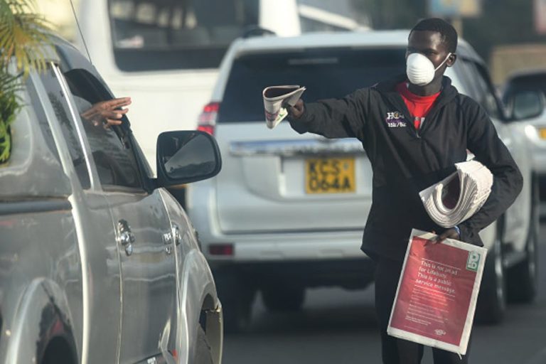 Un vendedor distribuye periódicos con máscara facial como medida preventiva contra la propagación del coronavirus COVID-19 en Nairobi, Kenya. Imagen: Simon Maina/AFP vía Getty Images